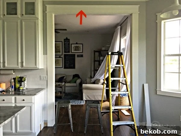 Installing the completed craftsman door header above the doorway, ensuring level and centered placement.
