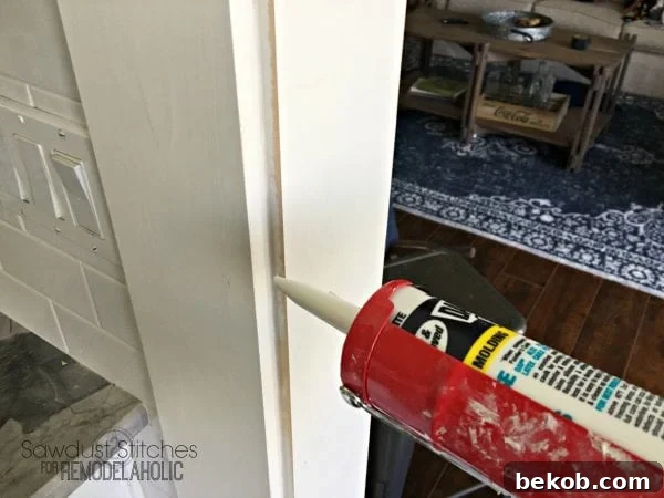Applying caulk to all seams around the door casing for a clean, finished look.