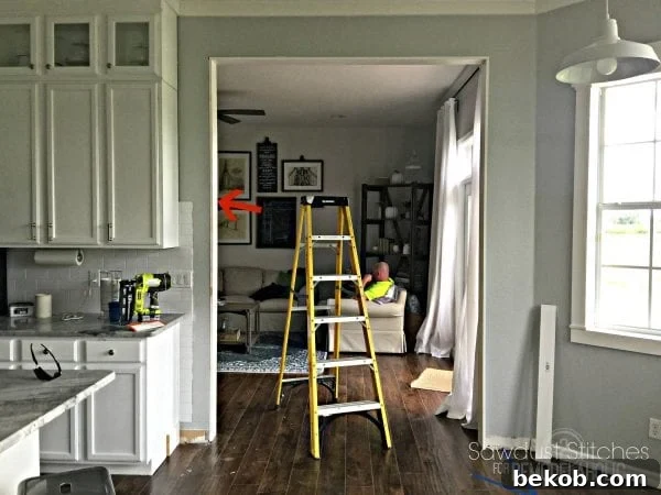 Using a nail gun to secure the interior side casing board, ensuring stability.