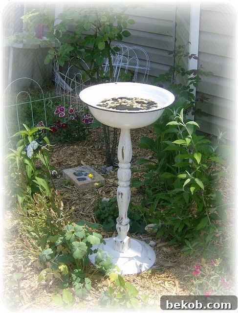 A charming DIY bird bath crafted from a repurposed carved table leg and an enamel bowl.
